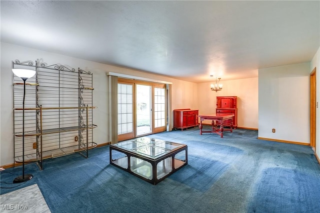 carpeted living room with a chandelier and baseboards