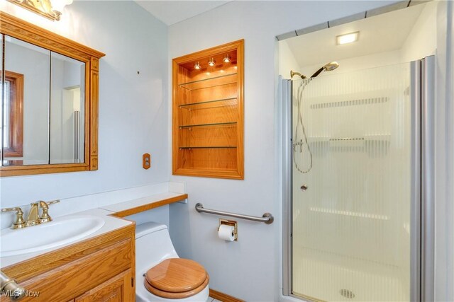 bathroom featuring a stall shower, toilet, and vanity