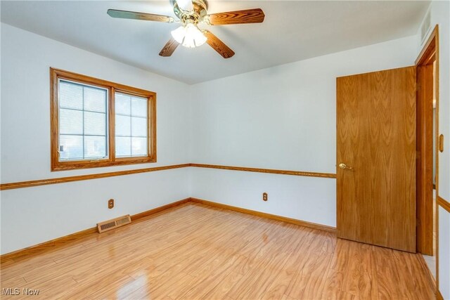 empty room featuring light wood-style floors, ceiling fan, and baseboards