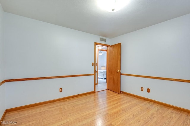unfurnished room with light wood finished floors and baseboards