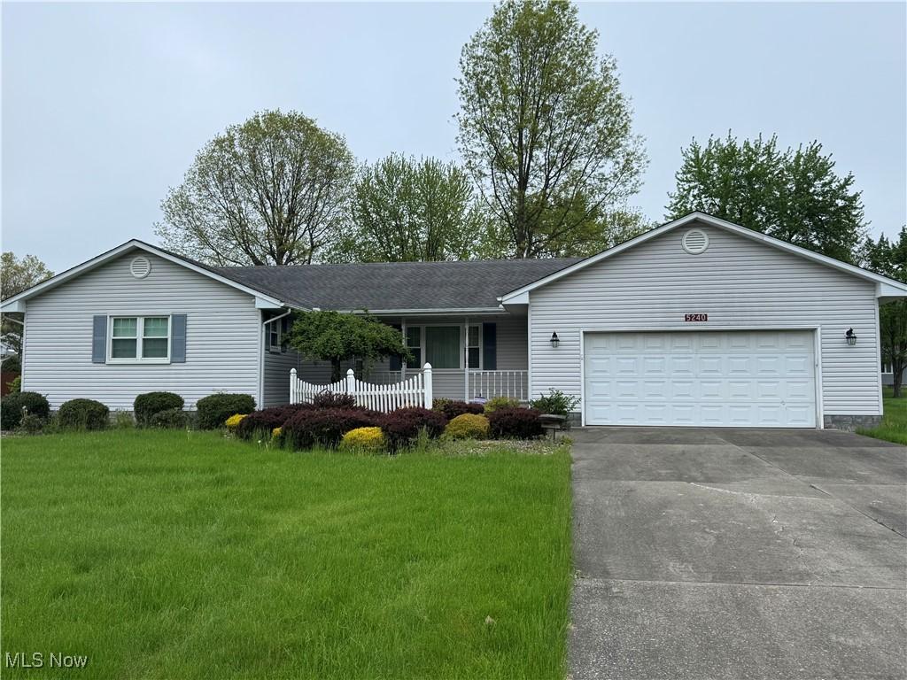 5240 Sabrina Ln, Warren, OH 44483 - ranch-style home featuring a porch, a front lawn, concrete driveway, and an attached garage