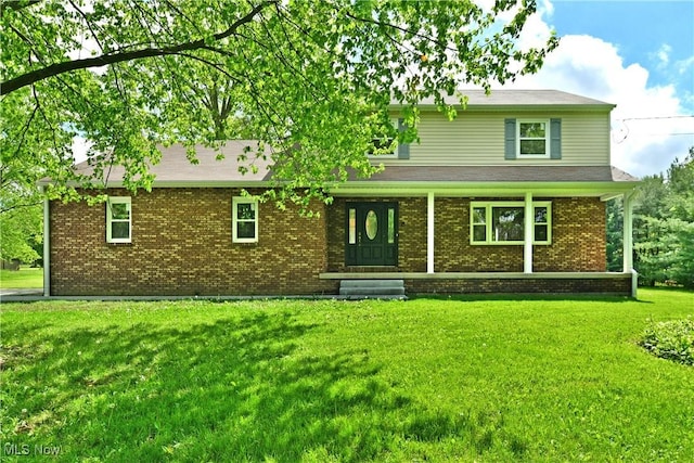 view of front of property featuring a front lawn, brick siding, and covered porch