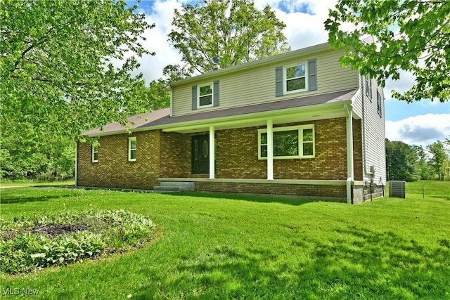 traditional home with a front lawn, brick siding, central air condition unit, and a porch