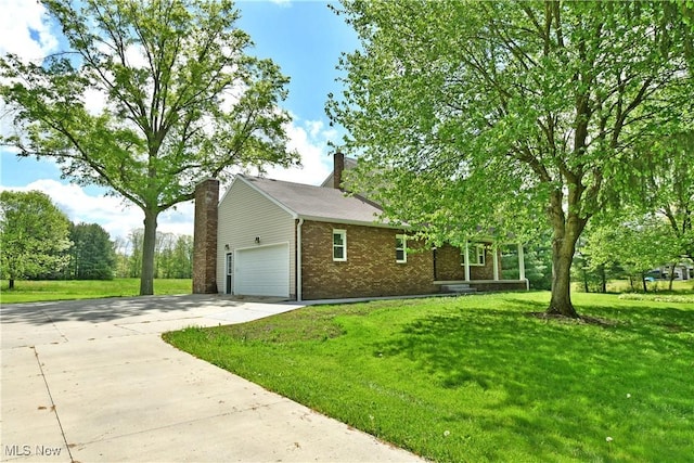 view of front of home with brick siding, concrete driveway, a front yard, and an attached garage