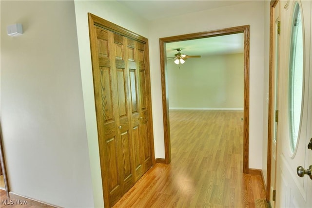 hallway featuring light wood-style floors and baseboards