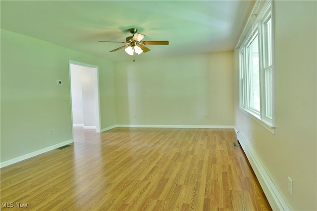 unfurnished room with a baseboard radiator, a ceiling fan, light wood-style floors, and baseboards