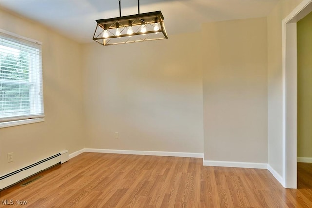 unfurnished dining area with a baseboard heating unit, light wood-type flooring, and baseboards