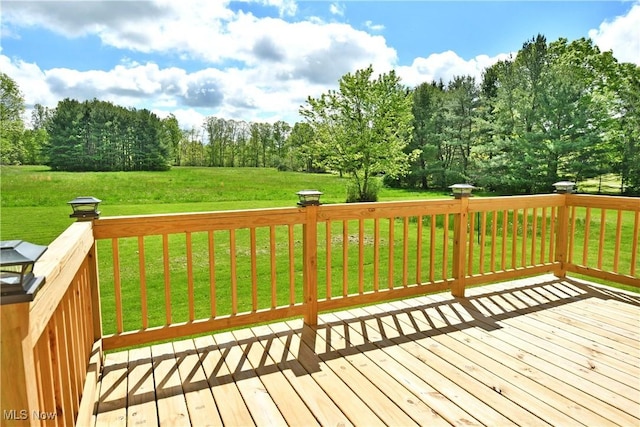 deck with a yard and view of wooded area