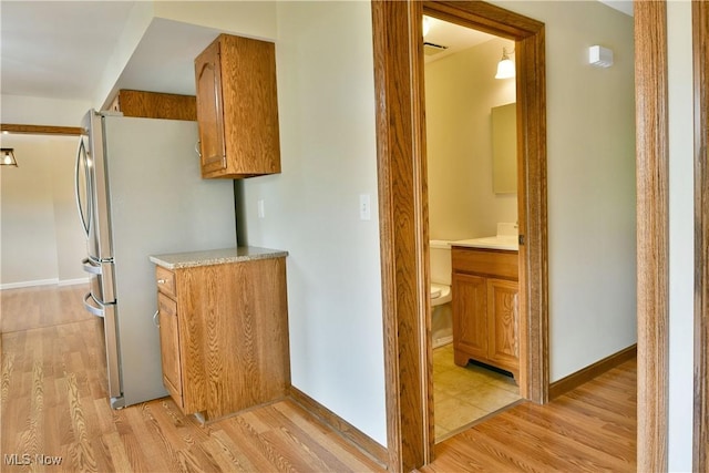 corridor with light wood-style floors and baseboards