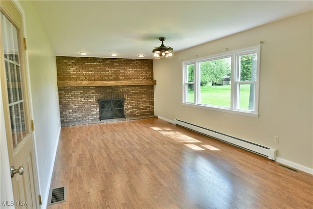 unfurnished living room with a baseboard radiator, wood finished floors, a brick fireplace, and baseboards
