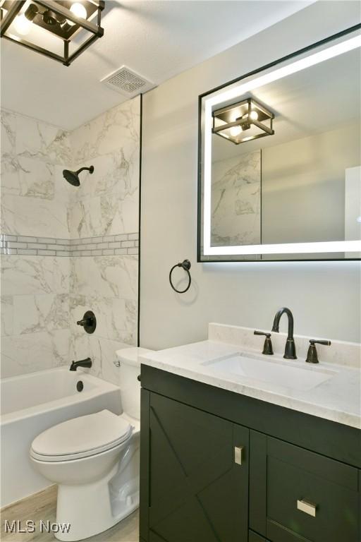full bath with toilet, vanity, and shower / washtub combination