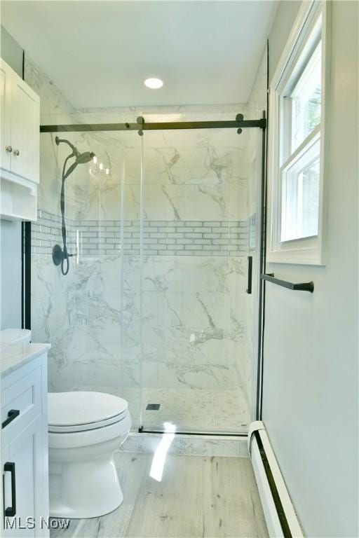 full bathroom with toilet, baseboard heating, vanity, a marble finish shower, and recessed lighting
