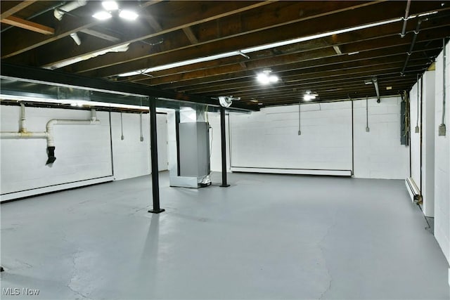 unfinished basement with a baseboard radiator and electric panel