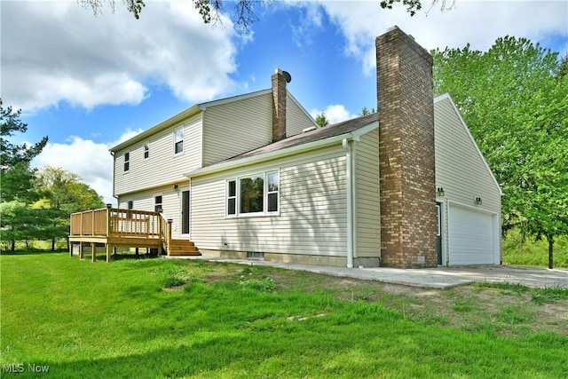 rear view of house with a chimney, a wooden deck, a yard, a garage, and driveway
