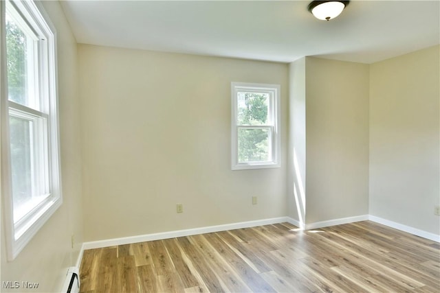 empty room with light wood-style flooring and baseboards