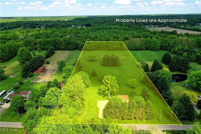 aerial view of property and surrounding area with property parcel outlined and a forest