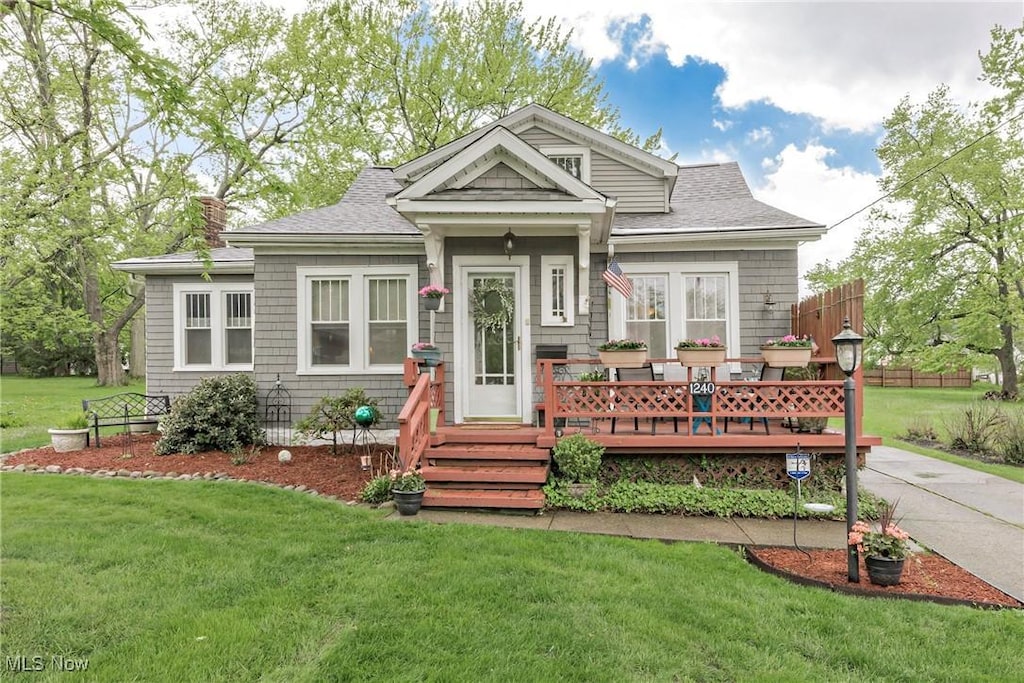1240 Elmwood Rd, Mayfield Heights, OH 44124 - view of front facade featuring a front yard, a deck, and roof with shingles