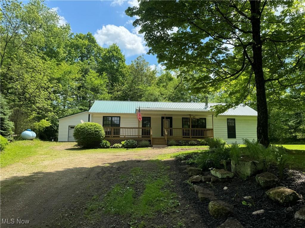 321 Ho Hum Dr, Brinkhaven, OH 43006 - ranch-style home featuring covered porch, metal roof, dirt driveway, and a front yard