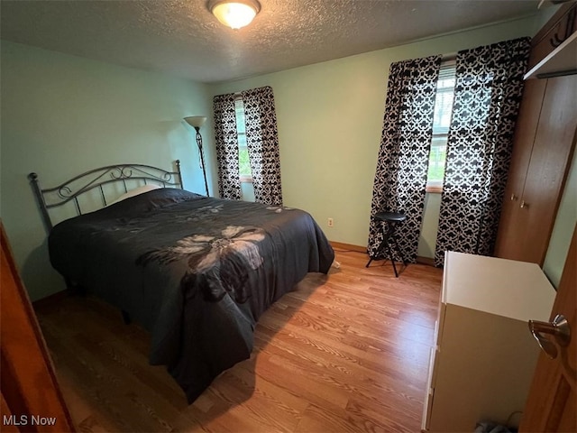 2165 Stony Hill Rd, Hinckley, OH 44233 - bedroom featuring light wood-style floors, a textured ceiling, and baseboards