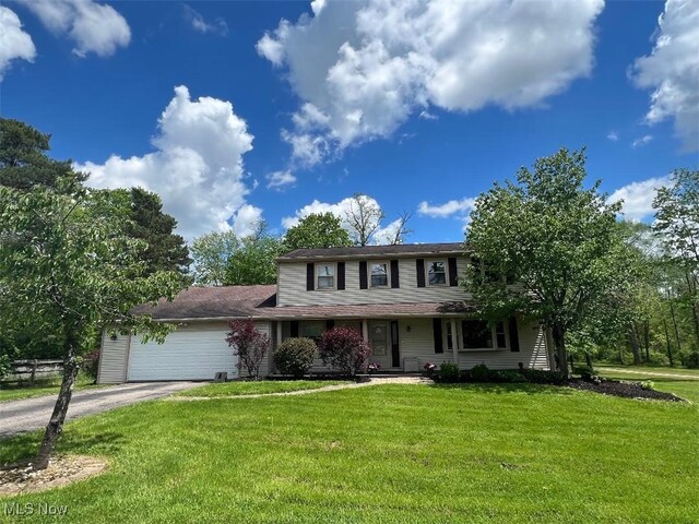 2165 Stony Hill Rd, Hinckley, OH 44233 - view of front of property with asphalt driveway, a front lawn, an attached garage, and covered porch