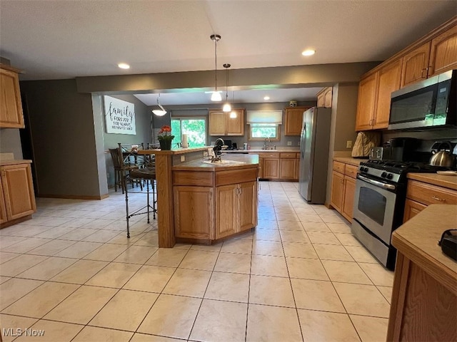2165 Stony Hill Rd, Hinckley, OH 44233 - kitchen with stainless steel appliances, light countertops, a breakfast bar, a kitchen island with sink, and light tile patterned floors