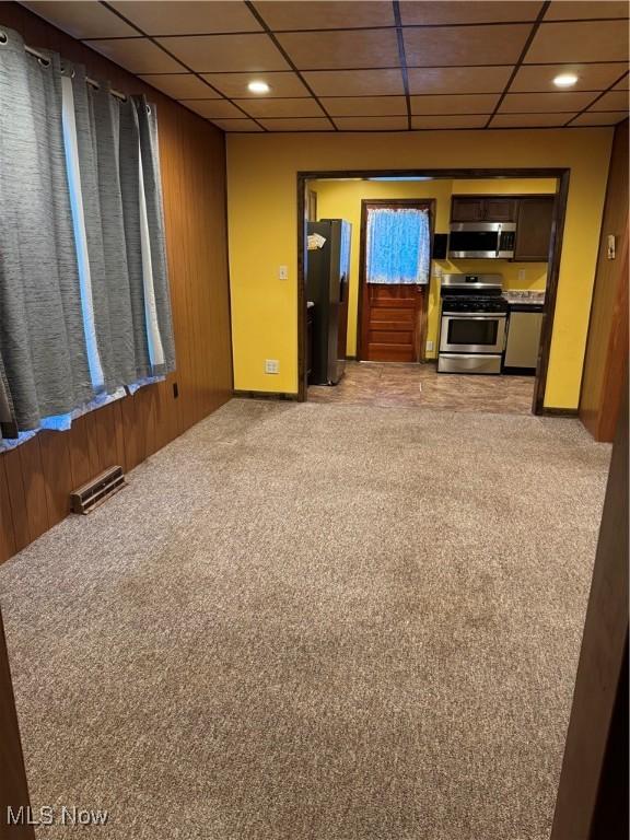 55960 National Rd, Bridgeport, OH 43912 - unfurnished living room featuring light colored carpet, a paneled ceiling, wood walls, and recessed lighting