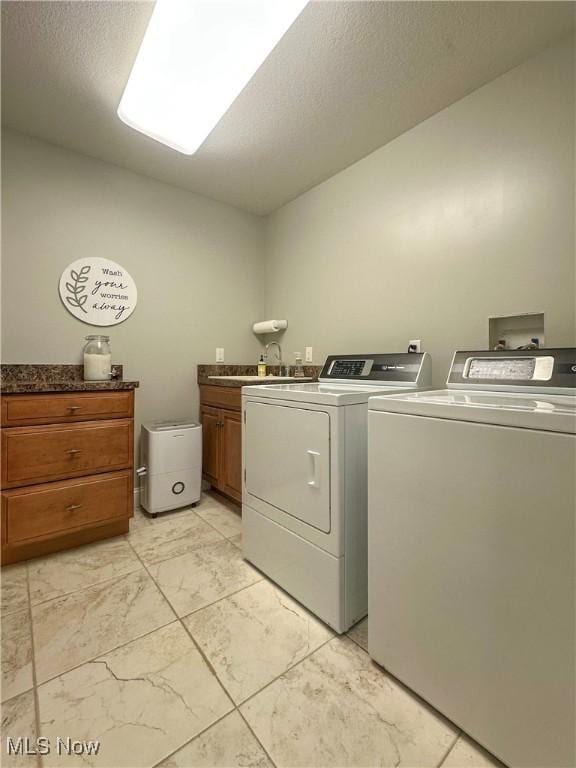 6836 Twin Oaks Ct, Canfield, OH 44406 - laundry room featuring separate washer and dryer, cabinet space, light marble finish floors, and a textured ceiling