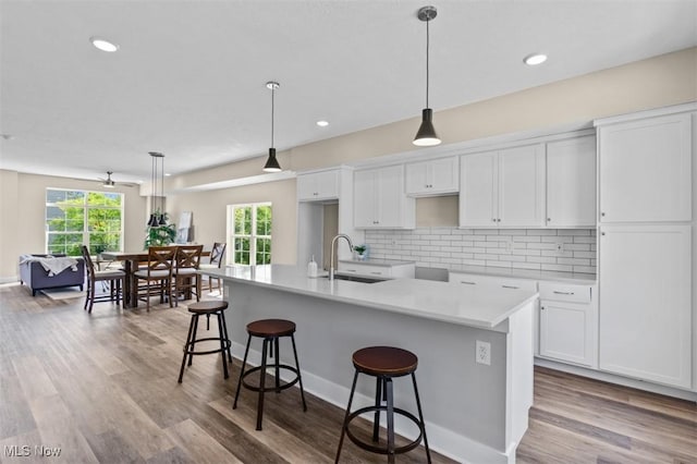 2087 Wynn Rd, Cleveland, OH 44118 - kitchen featuring a sink, white cabinets, a kitchen breakfast bar, backsplash, and recessed lighting