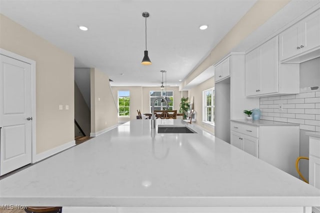2087 Wynn Rd, Cleveland, OH 44118 - kitchen featuring a sink, light countertops, white cabinetry, tasteful backsplash, and recessed lighting