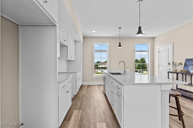 2087 Wynn Rd, Cleveland, OH 44118 - kitchen featuring a sink, light wood-style floors, light countertops, a breakfast bar, and recessed lighting