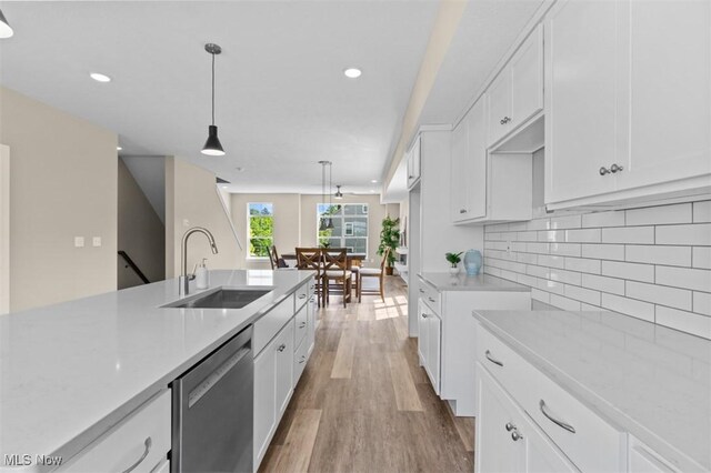 2087 Wynn Rd, Cleveland, OH 44118 - kitchen featuring a sink, stainless steel dishwasher, light countertops, light wood-type flooring, and white cabinets