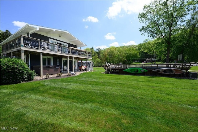 272 Cheyenne Trl, Malvern, OH 44644 - back of property with a lawn, a deck, a hot tub, and an outdoor fire pit