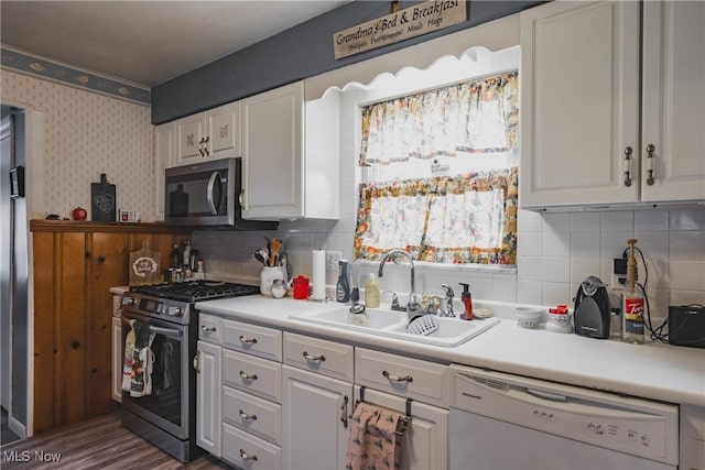 1608 Lawrence St, Parkersburg, WV 26101 - kitchen featuring appliances with stainless steel finishes, a sink, white cabinets, backsplash, and wallpapered walls