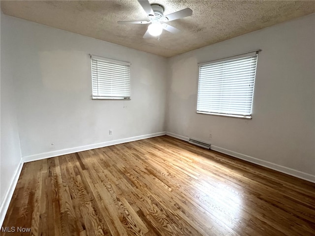 1585 Hilda St, Lakemore, OH 44250 - spare room featuring a ceiling fan, a textured ceiling, wood finished floors, and baseboards