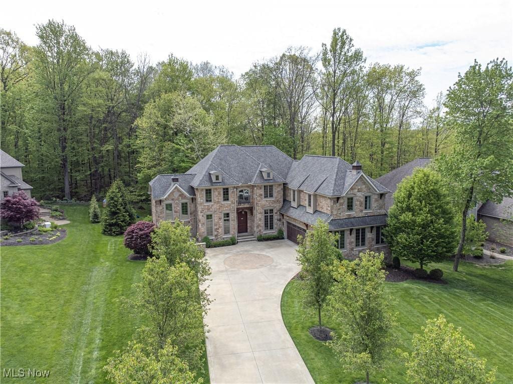 246 Stone Canyon Ct, Hinckley, OH 44233 - view of front of property with stone siding, driveway, an attached garage, and a front lawn