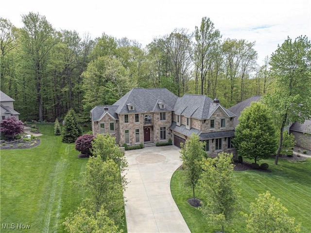246 Stone Canyon Ct, Hinckley, OH 44233 - view of front of property with stone siding, driveway, an attached garage, and a front lawn