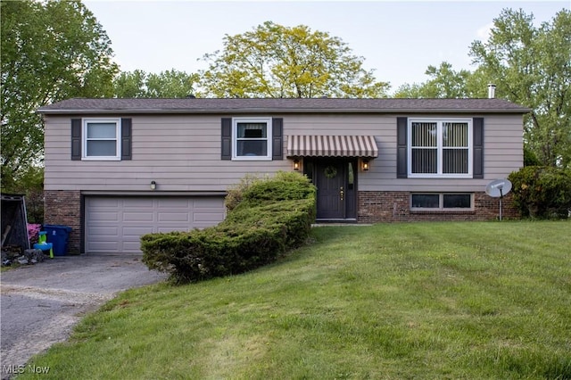 6333 Warren Sharon Rd, Oh, OH 44403 - split foyer home with a garage, asphalt driveway, brick siding, and a front lawn