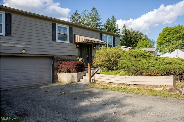 6333 Warren Sharon Rd, Oh, OH 44403 - raised ranch featuring a garage, driveway, and brick siding