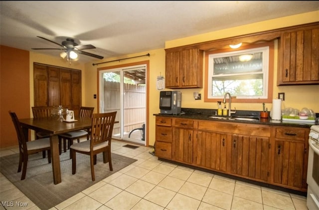 6333 Warren Sharon Rd, Oh, OH 44403 - kitchen featuring a sink, brown cabinets, ceiling fan, dark countertops, and light tile patterned floors