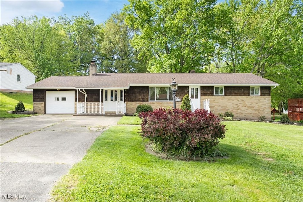 814 39th St SW, Canton, OH 44706 - ranch-style home featuring a garage, stone siding, a chimney, asphalt driveway, and a front lawn