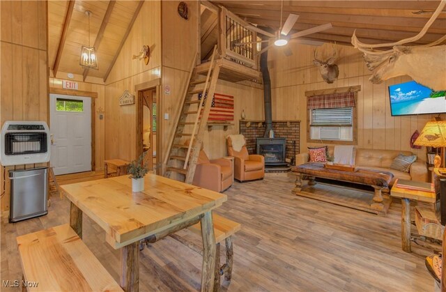 7324 Ferngreen Rd, Carrollton, OH 44615 - dining area featuring heating unit, wooden walls, a wood stove, stairway, and wood ceiling