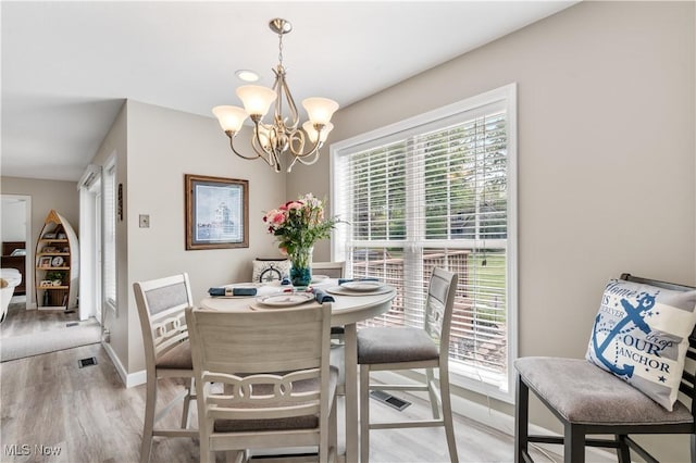 114 W Cherokee Trl, Bayview, OH 44870 - dining room featuring a chandelier, healthy amount of natural light, light wood-type flooring, and baseboards