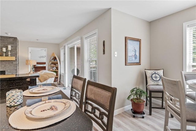 114 W Cherokee Trl, Bayview, OH 44870 - dining area featuring wood finished floors, baseboards, and a stone fireplace