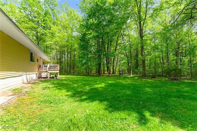 view of grassy yard with a deck
