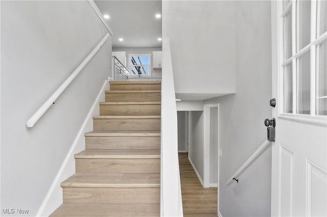 staircase with recessed lighting and wood finished floors