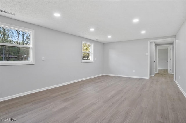 empty room featuring recessed lighting, wood finished floors, and baseboards