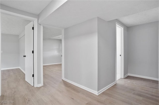 hall with light wood finished floors and baseboards