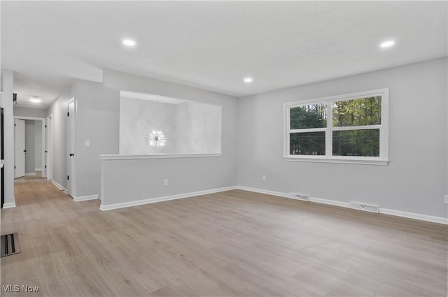 empty room with light wood-type flooring, baseboards, and recessed lighting