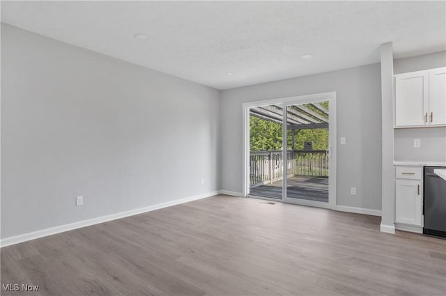 unfurnished living room with wood finished floors, baseboards, and recessed lighting