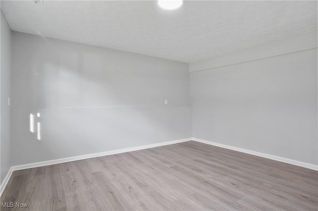 unfurnished room featuring wood finished floors and baseboards
